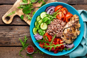 Greek rice bowl Top view. Wooden background