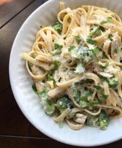 Fettuccine Alfredo with broccoli and chicken on a white plate